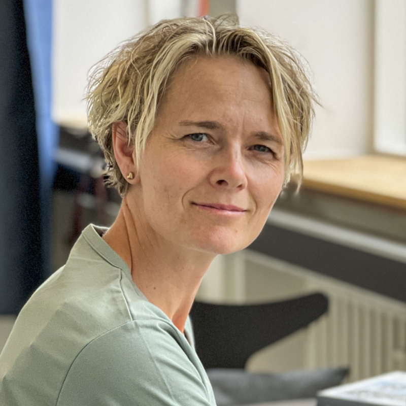 Imødekommende kvinde bag skrivebord – klar til at lytte og hjælpe