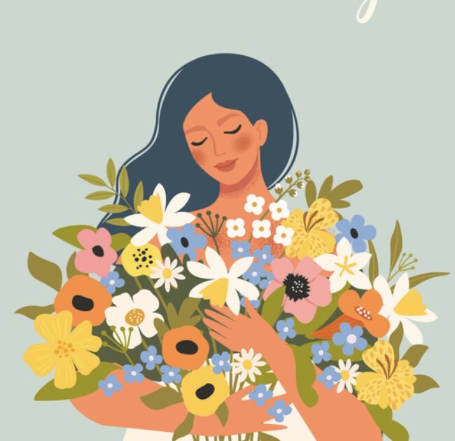 Smilende kvinde med lukkede øjne og favnen fuld af farverige blomster – et billede på styrke, eftertænksomhed og forandring i overgangsalderen.