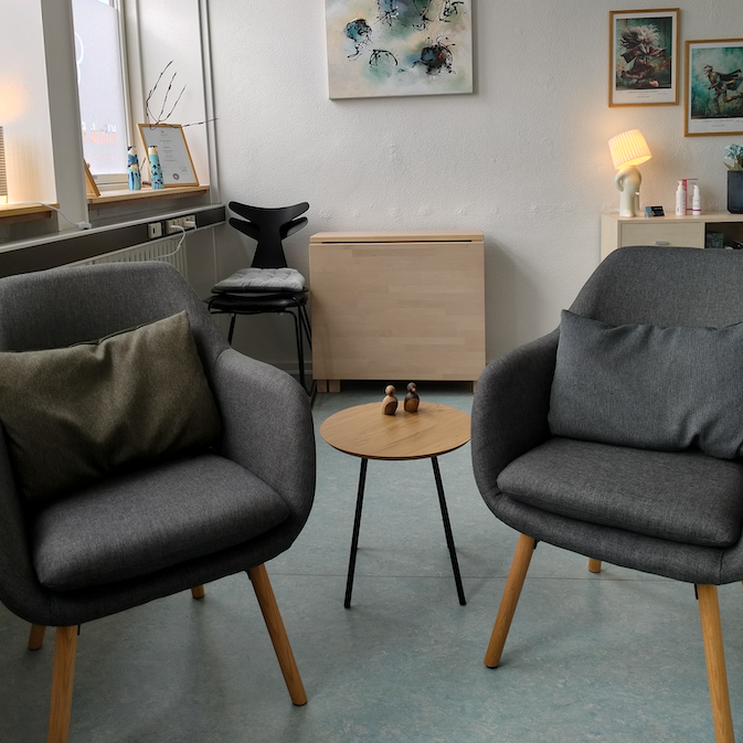 Komfortabel samtalestole i klinikken, hvor klienter tilbydes fortrolige samtaler om sexologiske emner.